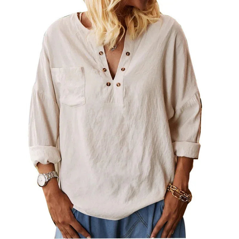 Woman wearing casual beige long-sleeve shirt with button details and chest pocket, paired with blue pants