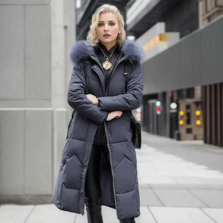 Blonde woman wearing long navy blue puffer coat with fur collar and black leather pants on city street