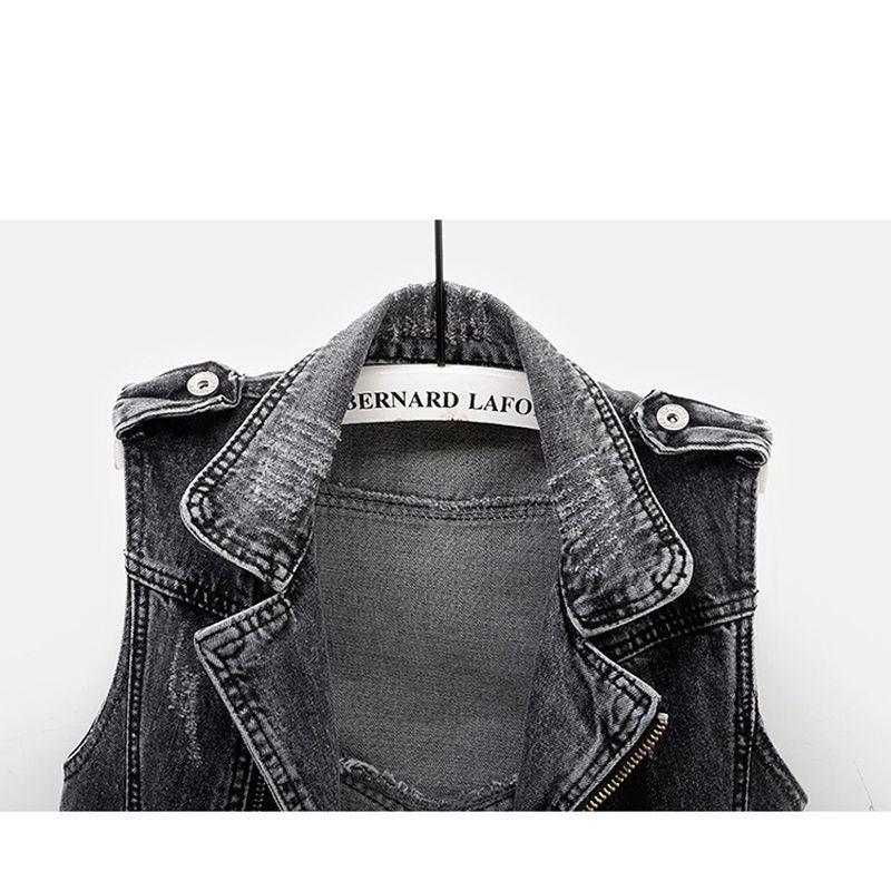 Black denim sleeveless jacket with collar and shoulder buttons hanging on a Bernard Lafond hanger