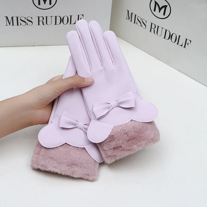 Light pink women's gloves with bow and faux fur cuffs, held by hand on white surface with Miss Rudolf branding