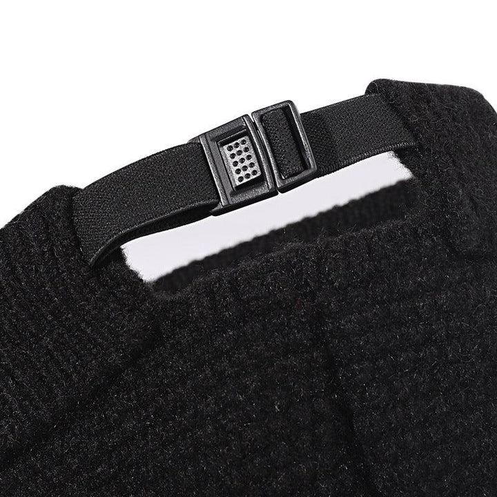 Close-up of adjustable black strap with plastic buckle on textured black knit fabric