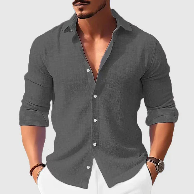 man wearing dark gray casual button-up shirt with rolled sleeves and white pants