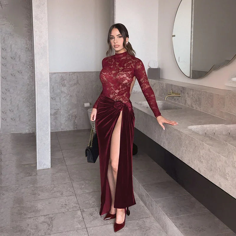 Woman in elegant burgundy lace and velvet evening gown with high slit, standing in modern bathroom