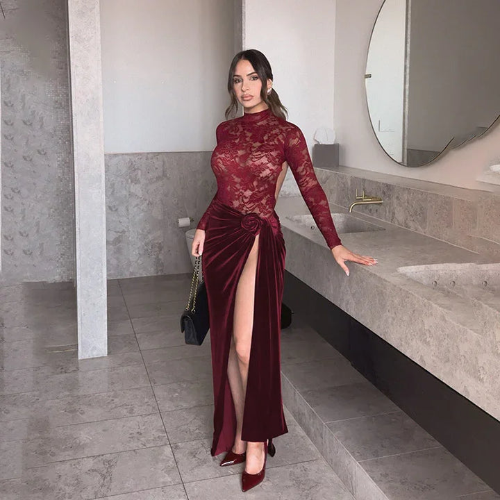 Woman in elegant burgundy lace and velvet evening gown with high slit, standing in modern bathroom