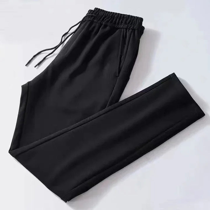 Black casual jogger pants with elastic waistband and drawstrings on white background