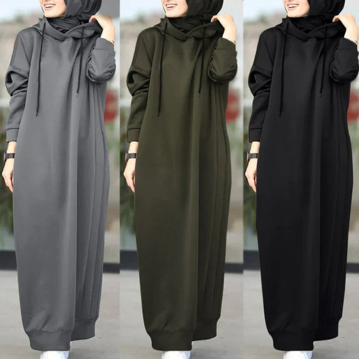 Woman modeling modest hooded abaya dresses in gray, olive green, and black with long sleeves outdoors