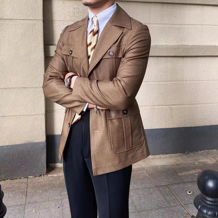 Man wearing brown double-breasted blazer with large pockets, striped tie, and black pants