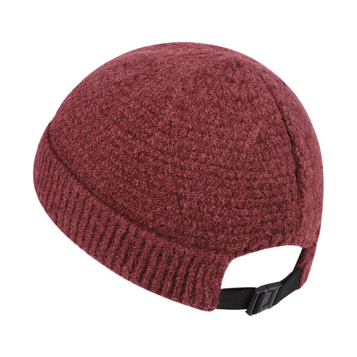 Maroon wool knit cap with adjustable black strap and buckle on white background