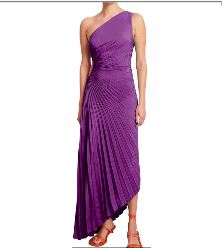Woman wearing one-shoulder purple pleated midi dress with asymmetrical hem and orange sandals