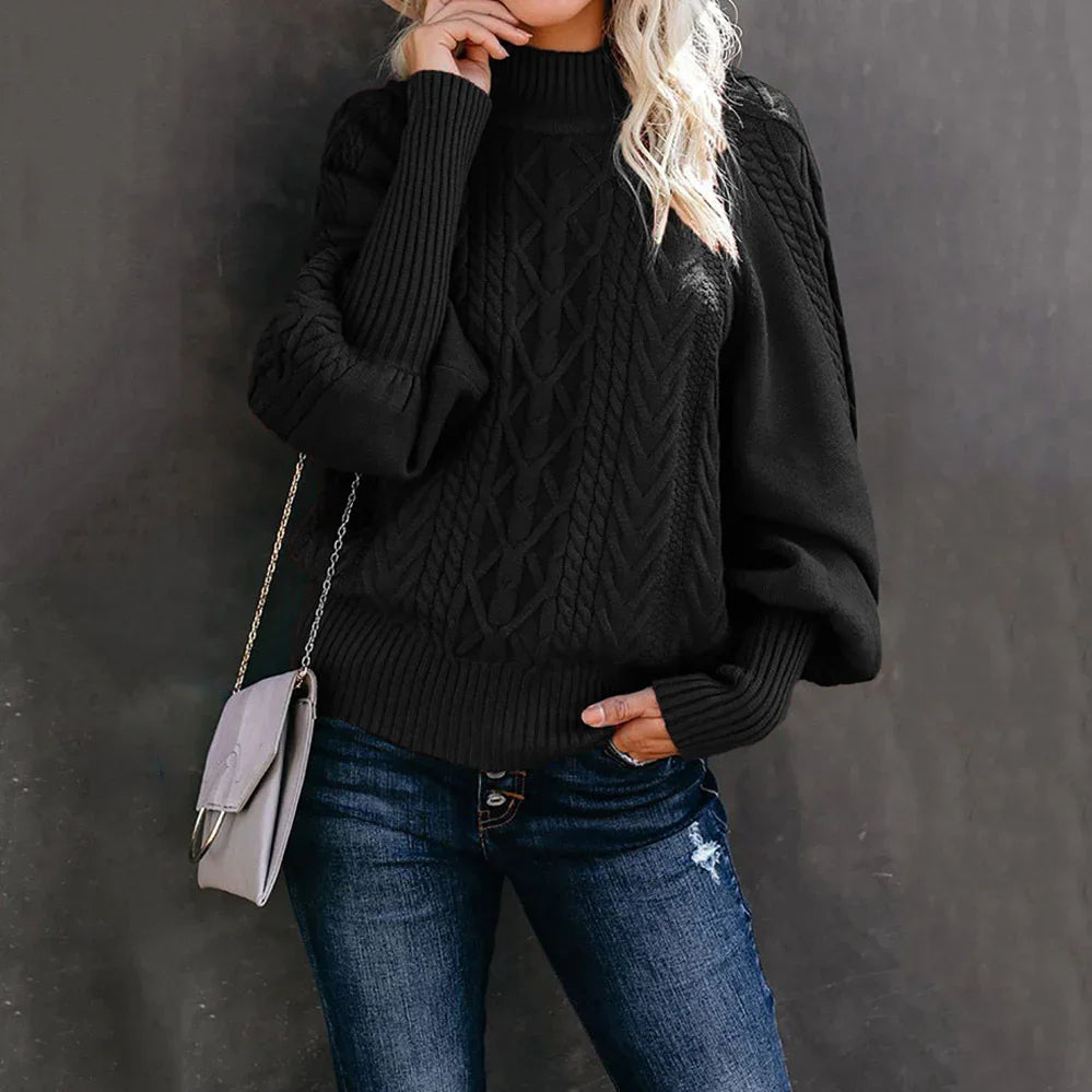 Woman wearing black cable knit turtleneck sweater with balloon sleeves and blue distressed jeans