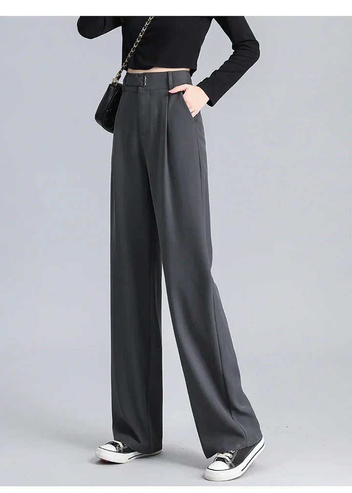 Woman wearing high-waisted wide-leg charcoal gray pants with black belt and black cropped top