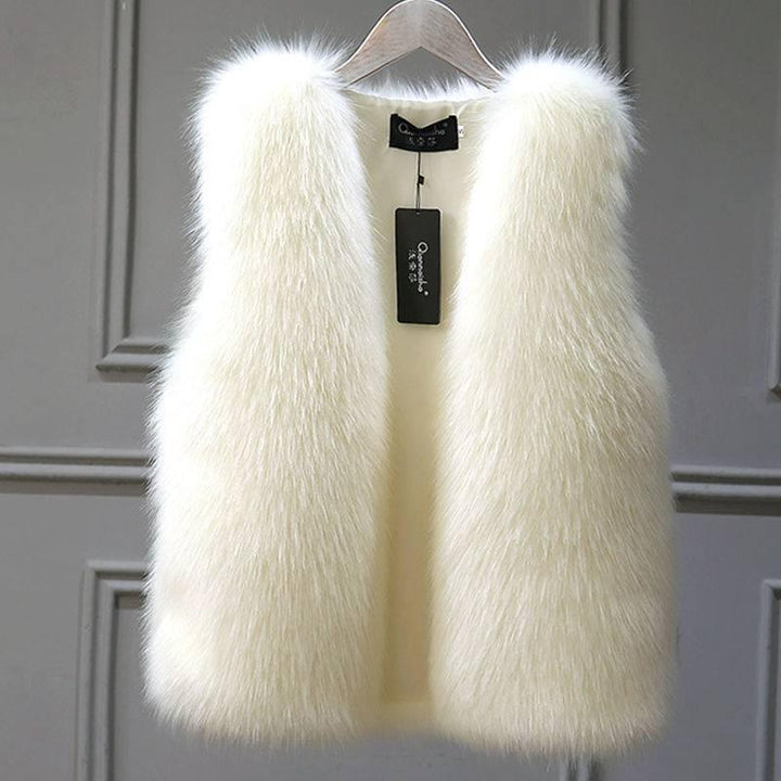 Elegant white faux fur sleeveless vest hanging on wooden hanger against gray panel wall