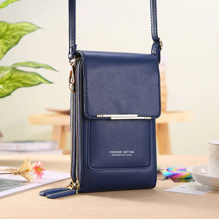 Navy blue leather crossbody bag with flap and gold zipper on beige table