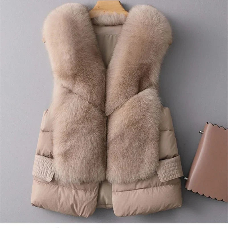 Beige fur vest with plush collar and padded sides hanging on wooden hanger against gray wall