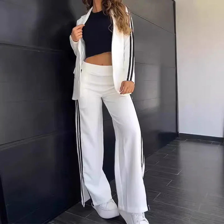 Woman wearing white striped wide-leg pants and matching jacket with black crop top and white sneakers