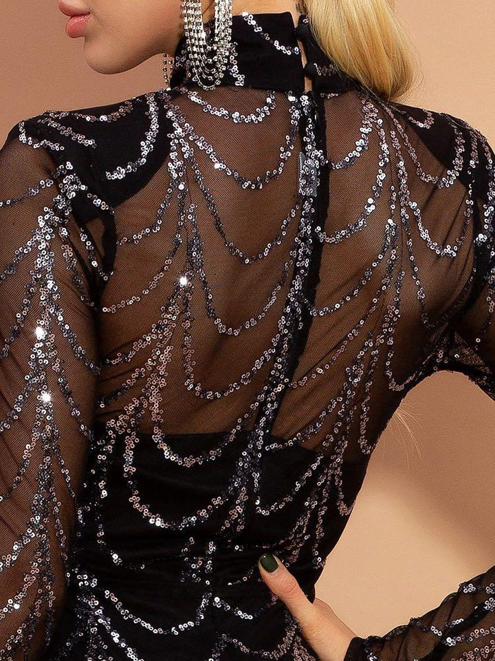 Close-up of woman wearing black sheer sequin dress with sparkling draped pattern and statement earrings