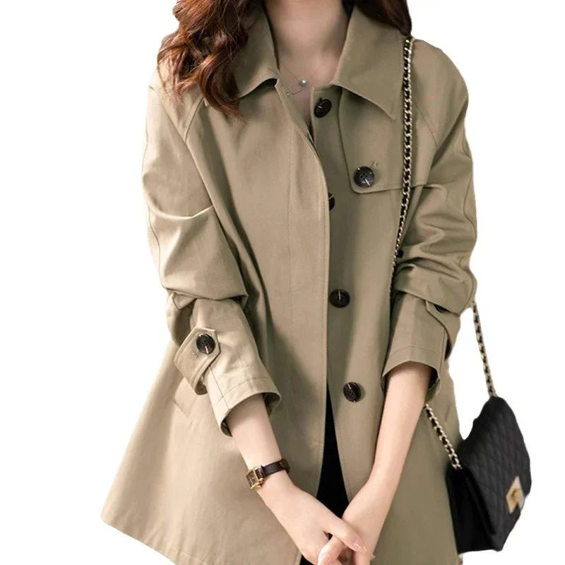 woman wearing beige trench coat with large buttons and black quilted purse with chain strap