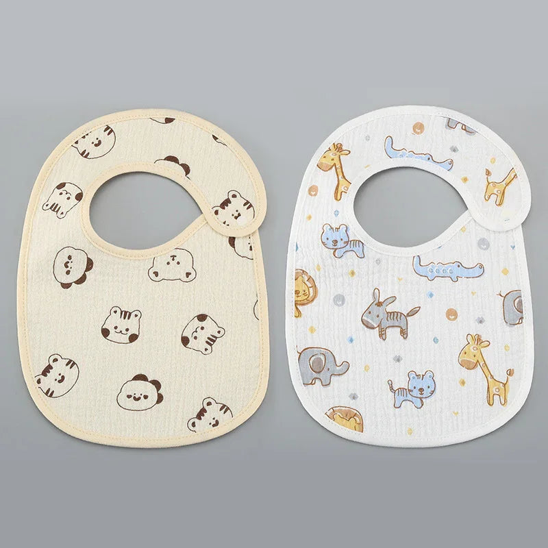 Two baby bibs with animal prints on gray background, one beige with cute animal faces, one white with colorful safari animals