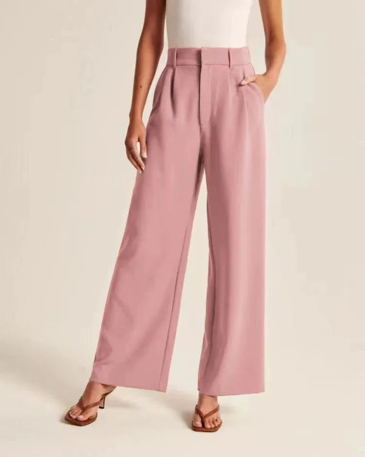 Woman wearing high-waisted pink wide-leg trousers with pleats and side pockets