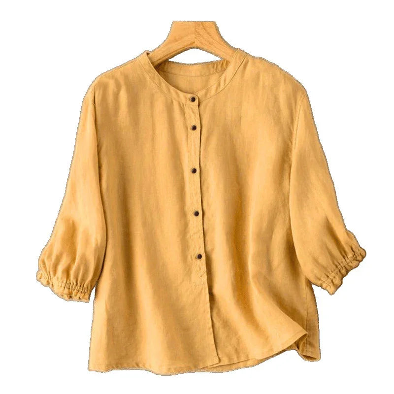 Mustard yellow linen blouse with round neck, button-down front, and elastic cuff sleeves on hanger