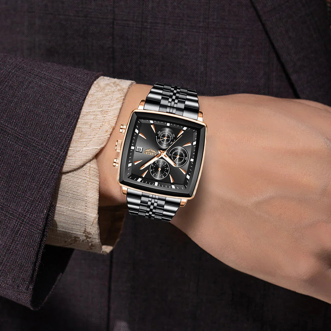 Luxury men's black and rose gold square wristwatch with chronograph on wrist in formal suit