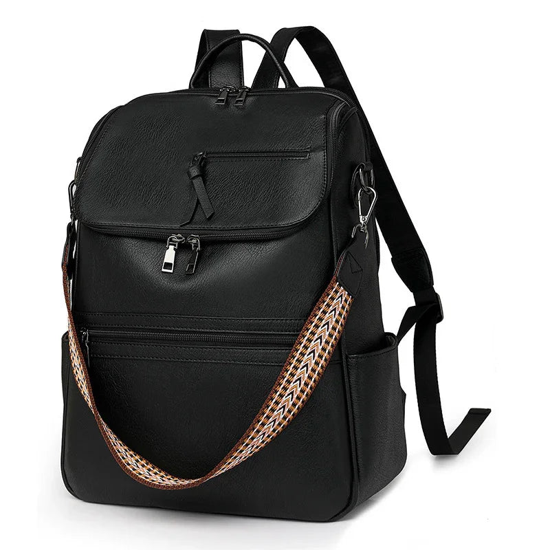 Black leather backpack with multiple zippered compartments and a detachable patterned shoulder strap