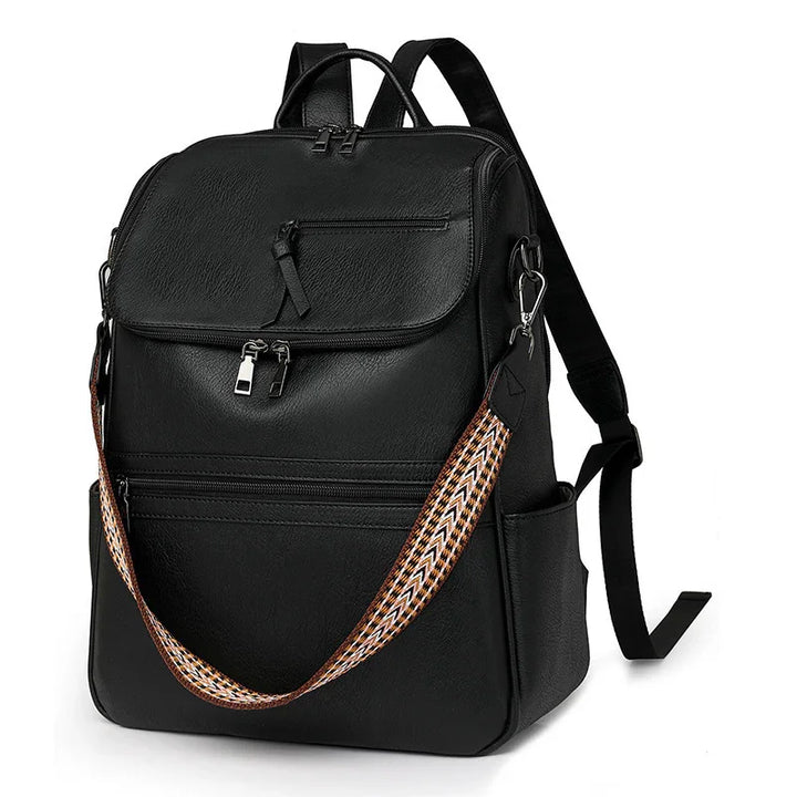Black leather backpack with multiple zippered compartments and a detachable patterned shoulder strap