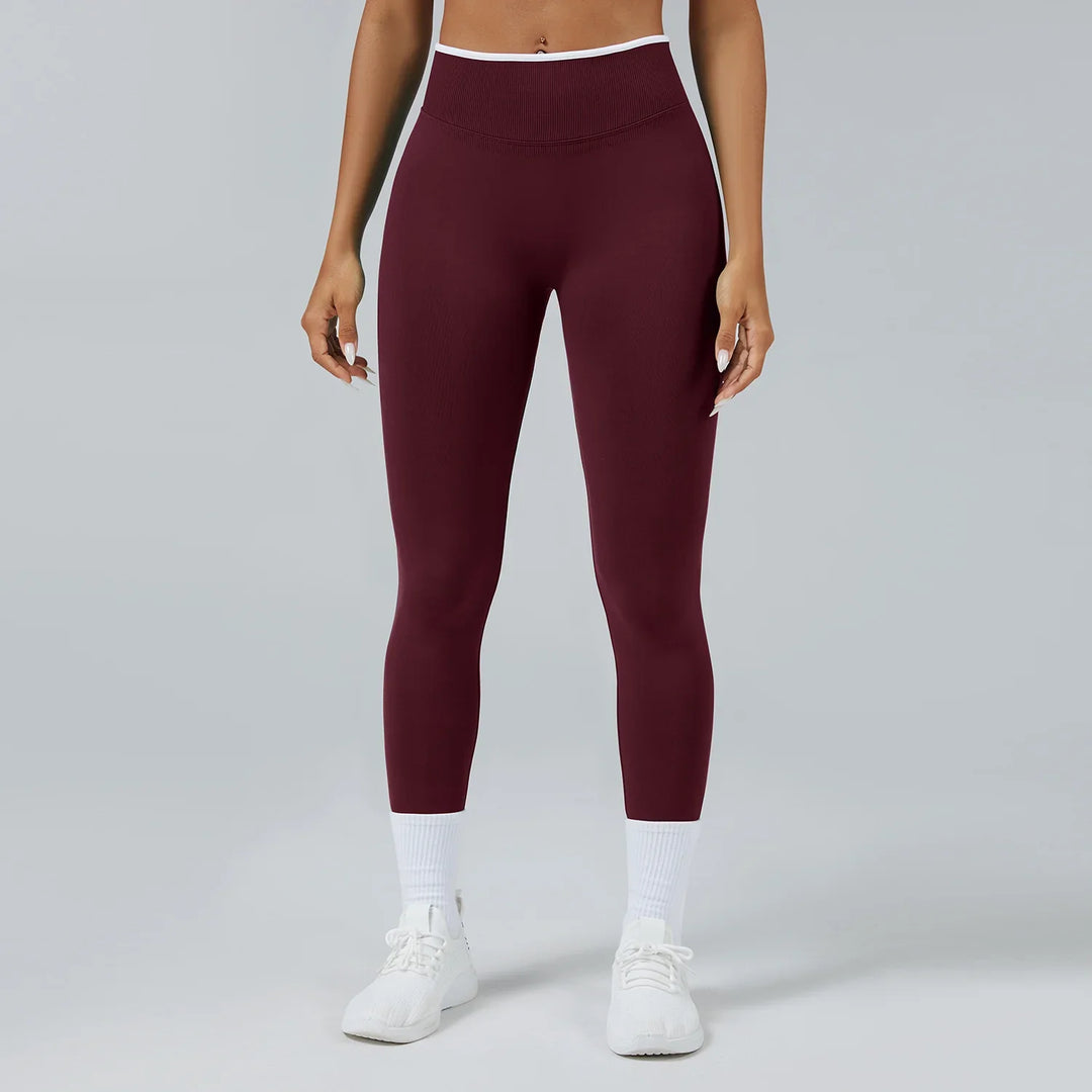 Close-up of woman wearing maroon high-waisted seamless leggings with white socks and white sneakers