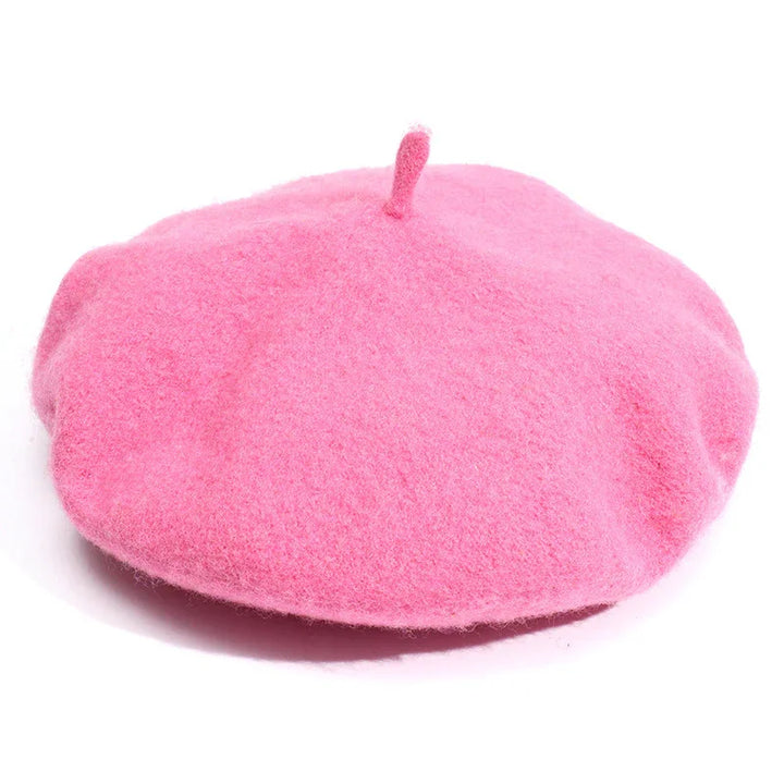 Soft pink wool beret hat with classic round shape and top stem on white background