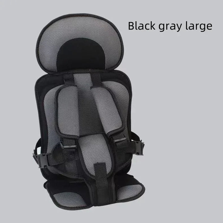 Black and gray large child safety harness seat with padded straps on gray background