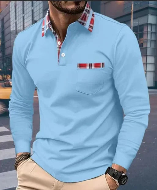 Man wearing light blue long sleeve shirt with red plaid collar and pocket detail in urban setting
