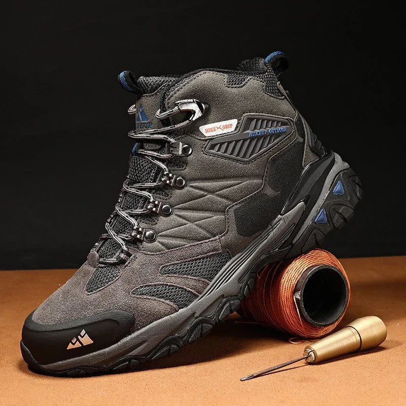 Gray and black hiking boot with steel toe, rugged sole, and hiking gear on brown surface