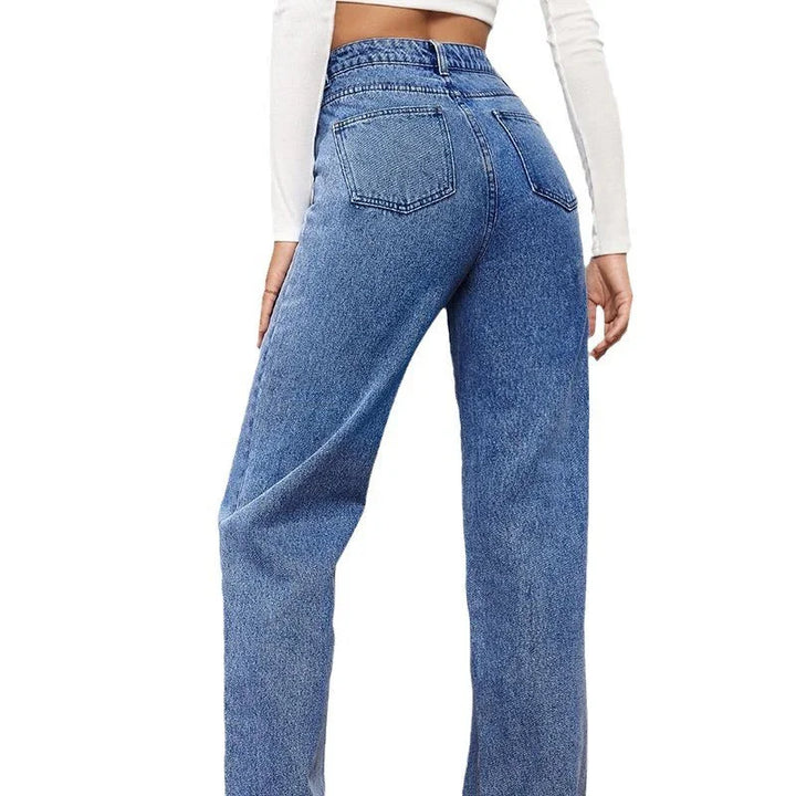 Back view of woman wearing high-waisted blue denim jeans and white crop top