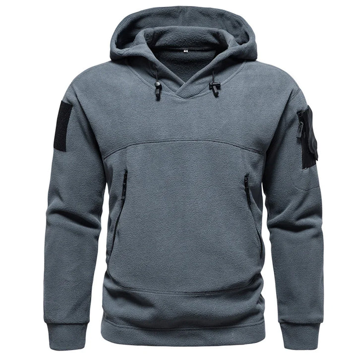 Gray fleece tactical hoodie with zip pockets, arm patches, and adjustable hood