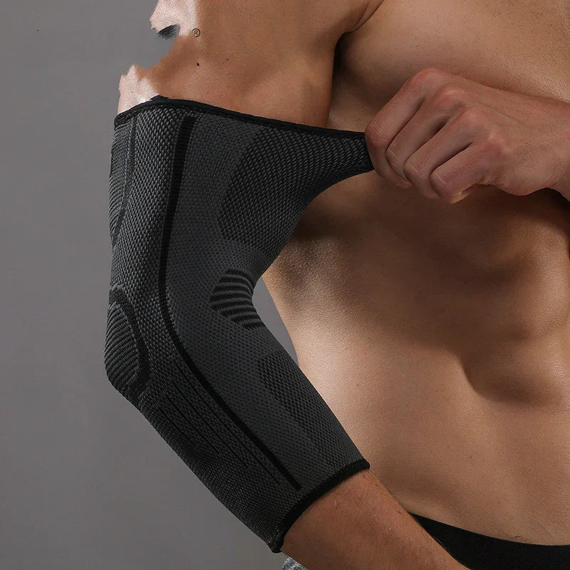 Man wearing black compression elbow sleeve on bare arm, close-up fitness accessory