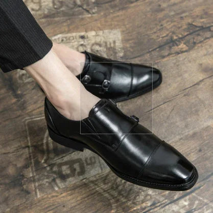 men's black leather dress shoes on wooden floor with buckle detail