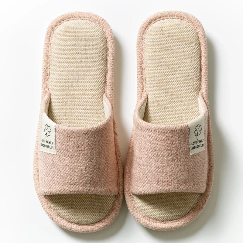Pink open-toe house slippers with fabric label saying love family and love life