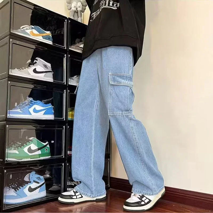 Person wearing light blue cargo jeans and black and white sneakers standing next to a stacked sneaker display