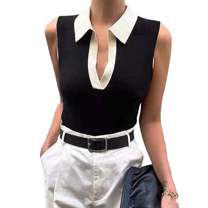 Sleeveless black top with white collar paired with high-waisted white pants and black belt