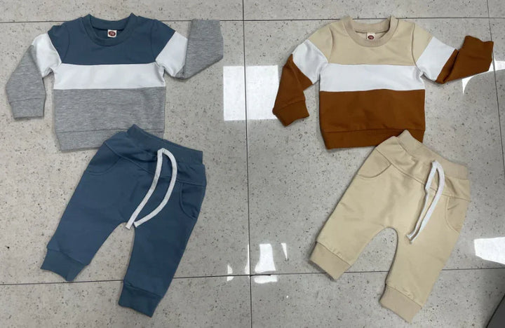 Two toddler colorblock outfits with long sleeves and matching drawstring pants on tiled floor