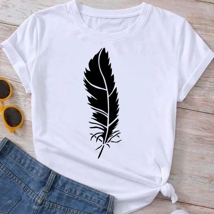 White t-shirt with large black feather graphic design, paired with blue jeans and yellow sunglasses on wooden surface