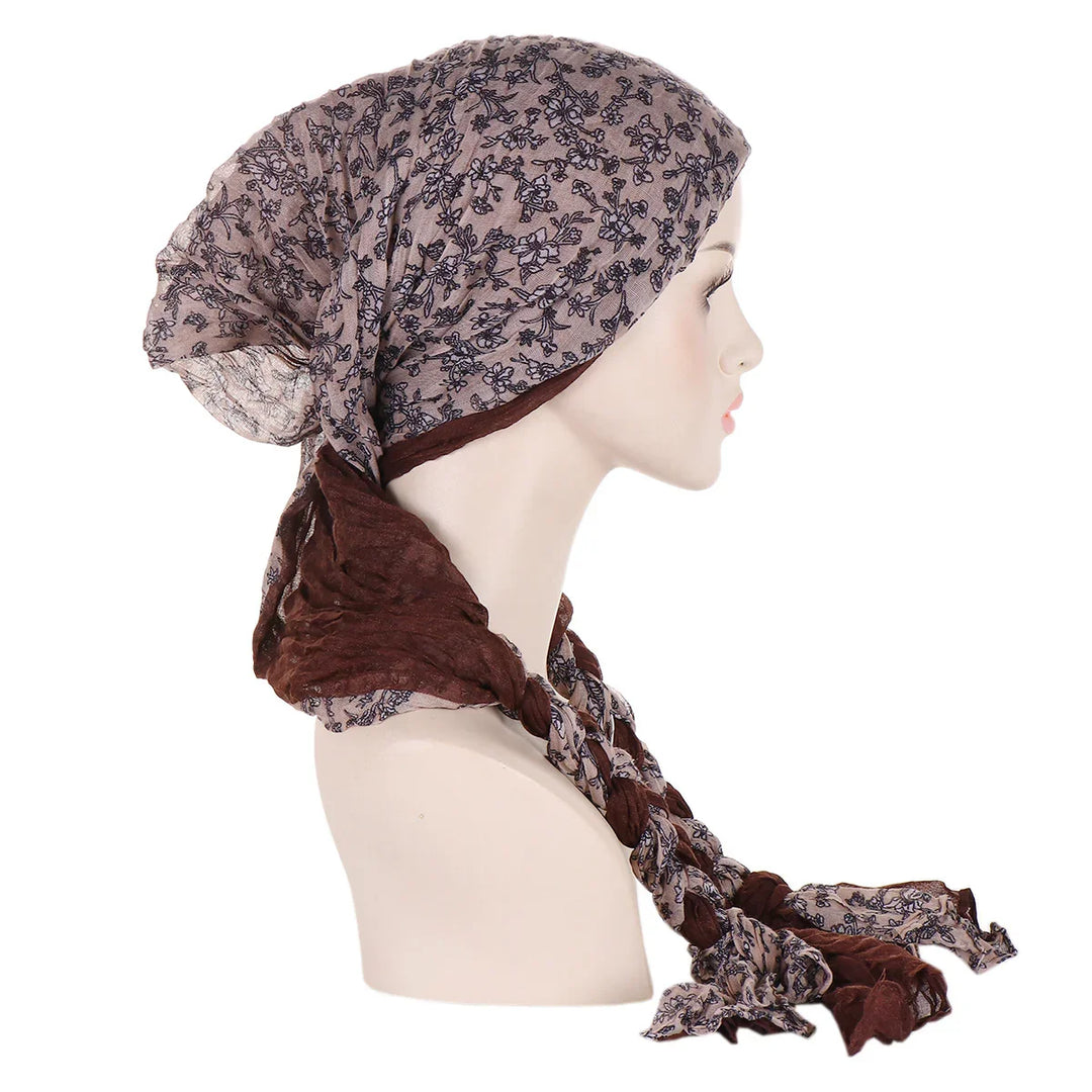 Side view of mannequin wearing brown and beige floral patterned headscarf with braided ends