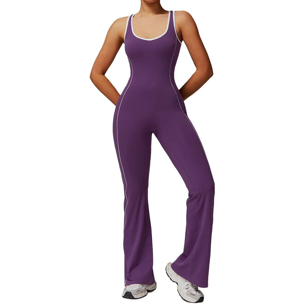 Woman wearing purple fitted sleeveless jumpsuit with white trim and sneakers on white background
