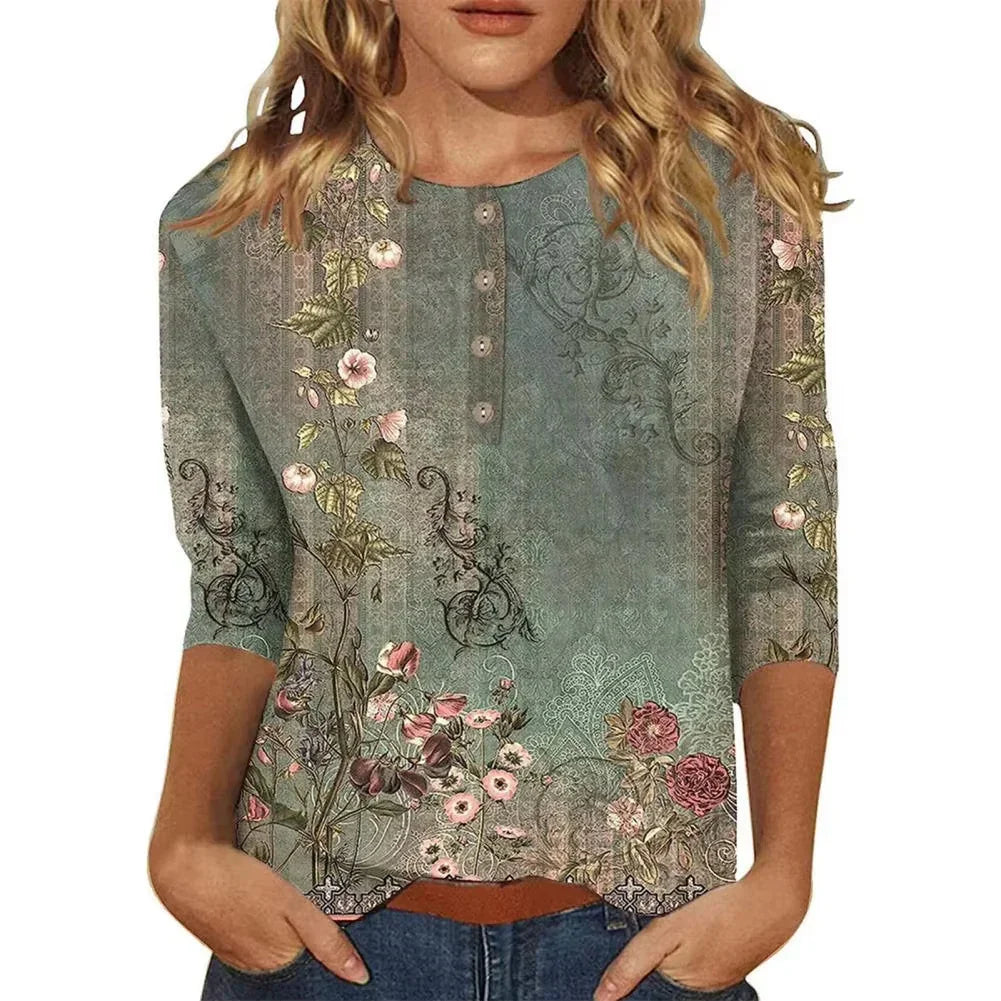 Woman wearing a green floral print blouse with buttons and 3/4 sleeves, paired with blue jeans