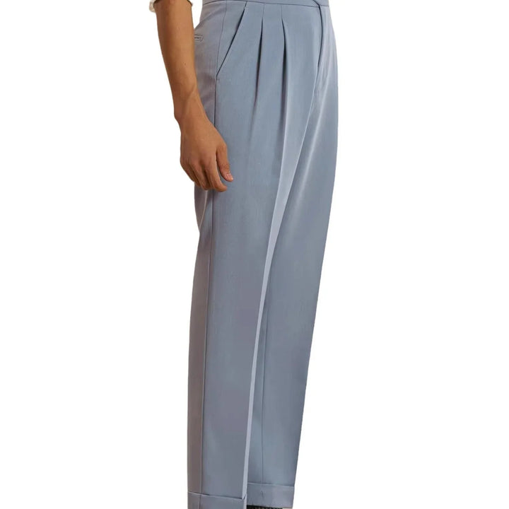 Side view of person wearing light blue pleated high-waisted dress pants with cuffed hems