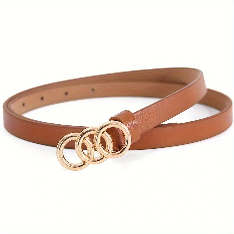 Slim tan leather belt with triple gold ring buckle on white background