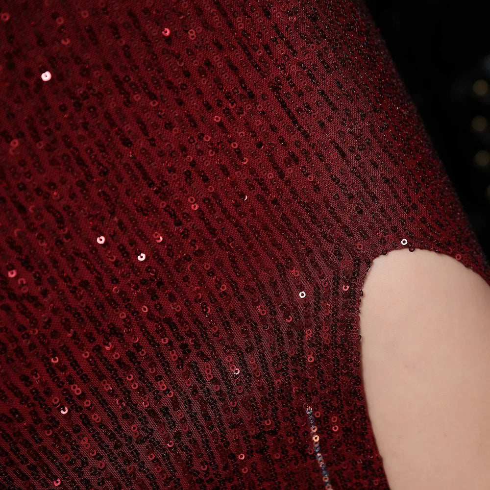 Close-up of shiny red sequin fabric with a cutout showing light skin beneath