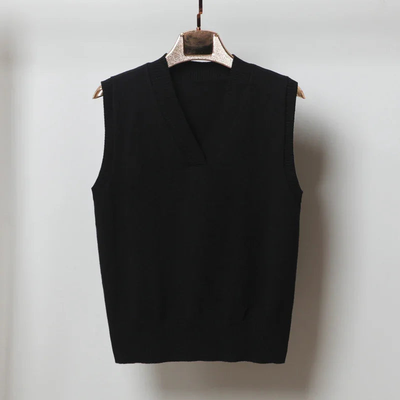 Black sleeveless V-neck knitted sweater vest on wooden hanger against plain wall