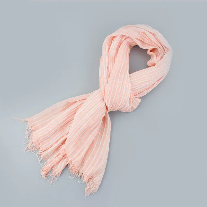 soft pink striped scarf with fringed ends on light gray background