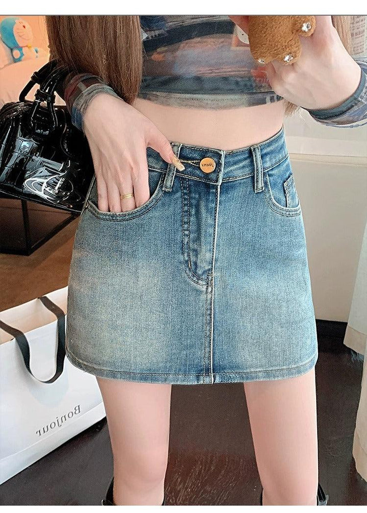 Close-up of woman wearing a faded blue denim mini skirt with gold button detail and front pockets